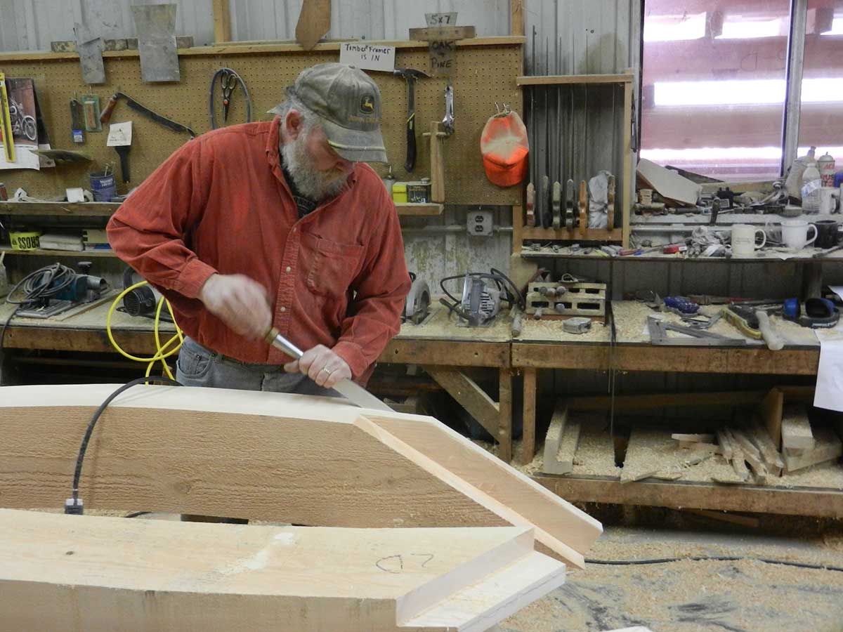 A craftsmen cuts the joint with a hand-held chisel